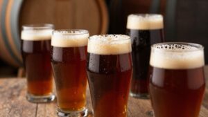Barrel-aged beers in glasses with wine barrels