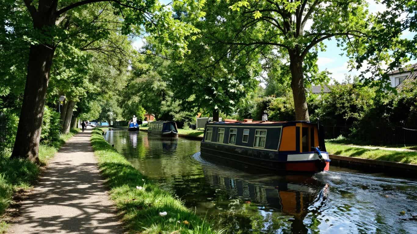 Canal du Midi with a boat and tree-lined path.
