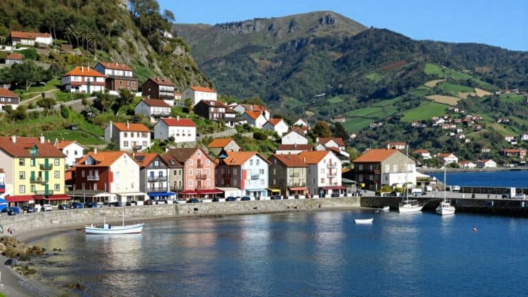 Colorful Basque village overlooking a blue bay and green mountains.
